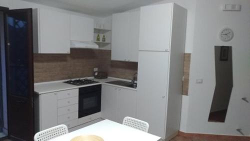 a kitchen with white appliances and a table and chairs at Case Susinna in Capaci