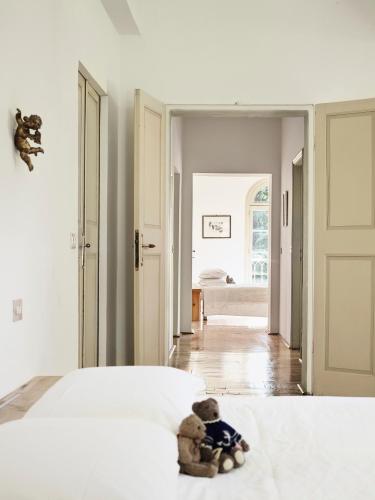 a teddy bear sitting on a bed in a bedroom at Le dimore de Il borgo del balsamico in Albinea