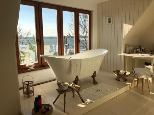 baño con bañera blanca y ventana en Seeblick Cottage, en Ziemitz
