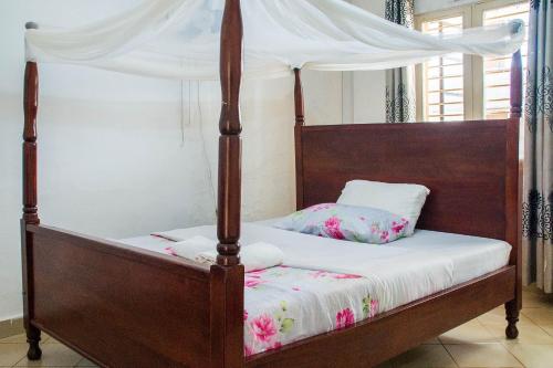 a bedroom with a four poster bed with a canopy at Bilkon Hotel Jinja in Jinja