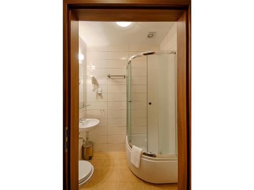 La salle de bains est pourvue d'une douche, de toilettes et d'un lavabo. dans l'établissement Hotel Yarden by Artery Hotels, à Cracovie