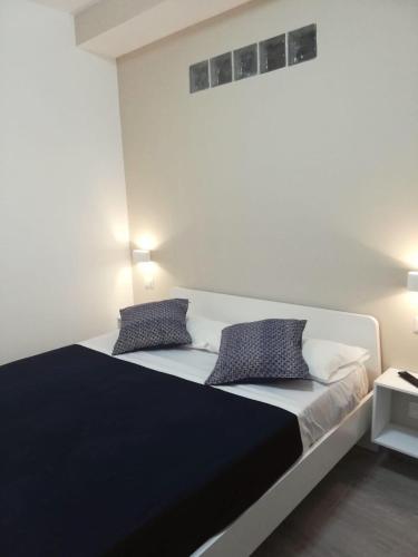 a bedroom with a large bed with two pillows at Cosmo Rooms a pochi passi da Tropea in Tropea