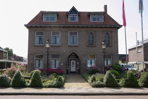 a brown brick house with a white door at Het Klooster van Dalfsen in Dalfsen