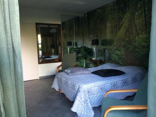 une chambre avec un lit avec une couette bleue dans l'établissement Chambre Foret du Mas des Fontaines, à Montagnac