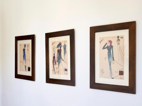 four framed pictures of people on a white wall at Le dimore de Il borgo del balsamico in Albinea