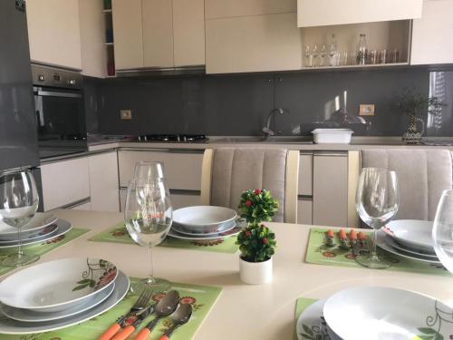 una cucina con tavolo, piatti e bicchieri da vino di SARA'S VILLA a Shkodër