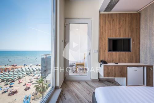 a bedroom with a view of a beach at Vila One Beach Hotel in Durrës