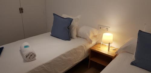 - une chambre avec 2 lits dotés d'oreillers bleus et d'une lampe dans l'établissement Alojamientos Segóbriga Rural (Tahona), à Segorbe