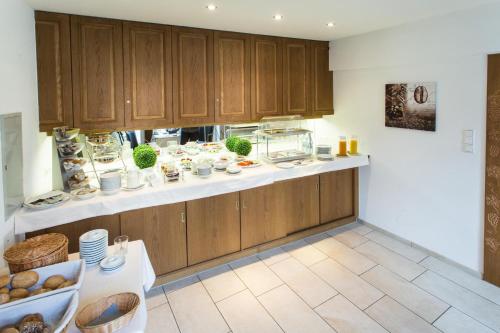 a kitchen with wooden cabinets and a counter top with dishes at Hotel Restaurant Lamm Rosswag in Vaihingen an der Enz