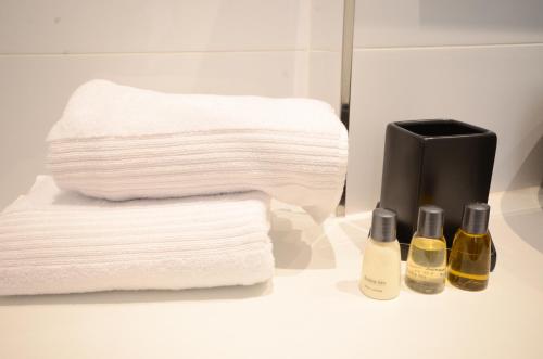 a pile of towels and two bottles of shampoo at Hotel Da Felice in Bopfingen