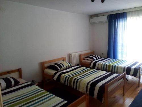 three beds in a room with a window at Apartments Hills in Ćukovi