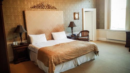 a bedroom with a large bed with a brown blanket at Colwick Hall Hotel in Nottingham