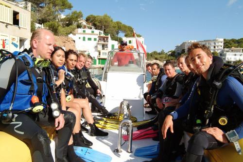 a group of people sitting on the back of a boat at Hotel Pinos Playa in Cala Santanyi