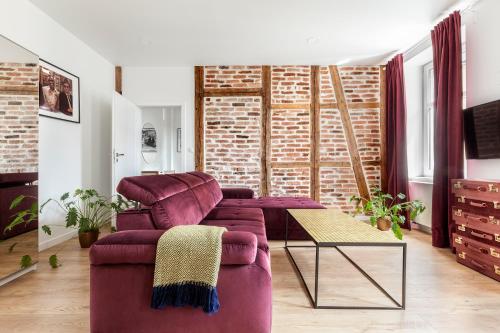 een woonkamer met een paarse bank en een tafel bij Cinema Apartments in Poznań