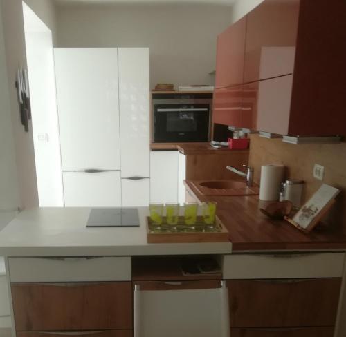 Apartma Zalka في إيزولا: مطبخ بخزائن بيضاء وطاولة خشبية