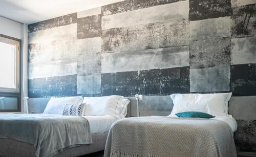 a bedroom with two beds and a wall with a mural at Residenza del Sele in Foggia