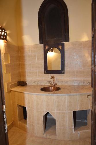 a bathroom with a sink and a mirror at Shanda Lodge Desert Resort in Al Qaşr