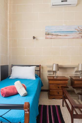 a bedroom with a bed with two towels on it at Acomodation House Kavarna in Xagħra