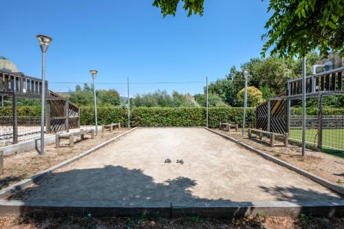 an empty basketball court in a park with benches at Comfort Aparthotel Mandelieu la Napoule Village in Mandelieu-la-Napoule