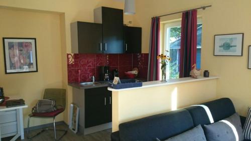 ein Wohnzimmer mit einem Sofa und einer Küche in der Unterkunft Ferienwohnung Sommerhus in Wiefelstede