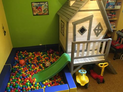 una sala de juegos para niños con un foso de bolas y una casa de juguetes en Sonnenhof Hechtl, en Mönichkirchen