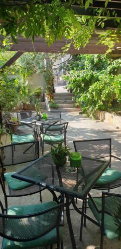 a group of tables and chairs under a pergola at Bed & Breakfast Dora in Rovanjska