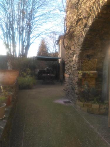 an outside view of a yard with a stone building at Le mas des sources cevenol Le chambon in Le Chambon