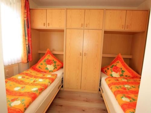 two beds in a small room with wooden cabinets at Ferienwohnung Wagner in Bad Bellingen