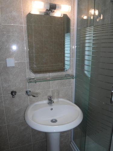 a bathroom with a sink and a glass shower at Guest House Budva in Budva