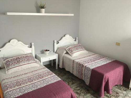 2 camas en una habitación pequeña con sábanas rosas en Orzola mar y relax, en Orzola