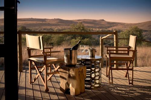 a table and chairs on a deck with a view at Cradle Boutique Hotel in Lanseria