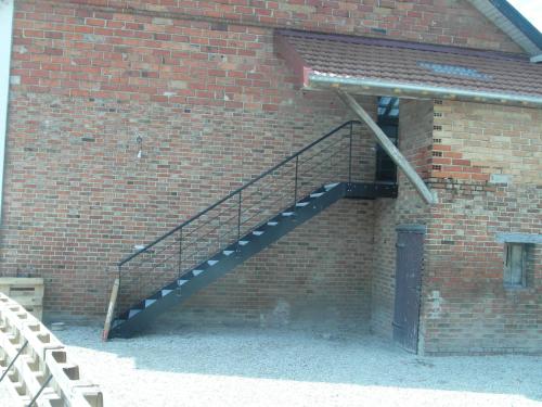 a brick building with a staircase on the side of it at La Garitinne in Onjon