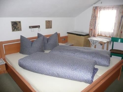 a bedroom with a large bed with blue pillows at Haus Wechner in Kappl