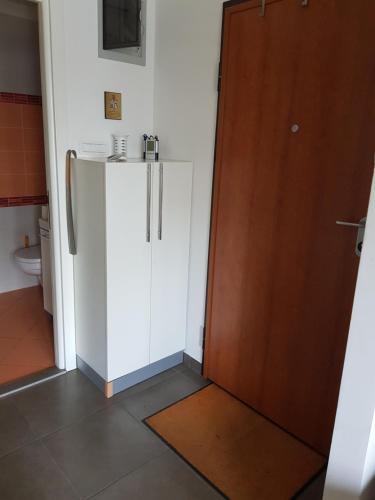 a kitchen with a white refrigerator next to a door at Lav apartments in Banja Luka