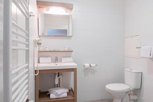 La salle de bains blanche est pourvue d'un lavabo et de toilettes. dans l'établissement Appart'City Confort Orléans, à Orléans