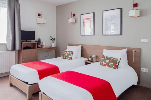 - une chambre avec 2 lits dotés de draps rouges et blancs dans l'établissement Appart'City Confort Orléans, à Orléans