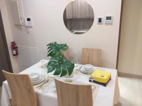 una mesa blanca con sillas y un jarrón encima en Apartamentos Vacacionales Joctis, Bajo B, en Fuengirola