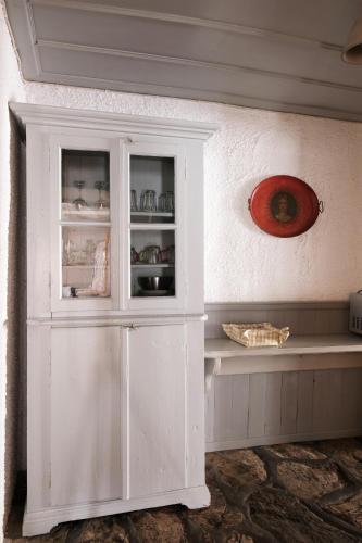 a white cabinet in a room with a plate on the wall at Keresbino Hydra Manor House in Hydra