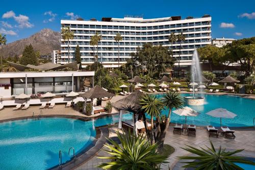 a large swimming pool with a large building behind it at Hotel Don Pepe Gran Meliá in Marbella