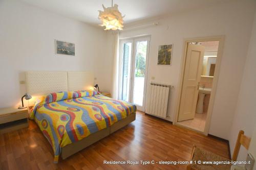 een slaapkamer met een bed met een kleurrijk dekbed bij Villa a Lignano Pineta in Lignano Sabbiadoro