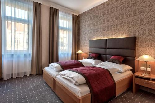 a bedroom with a large bed and a large window at Club Hotel Cortina in Vienna
