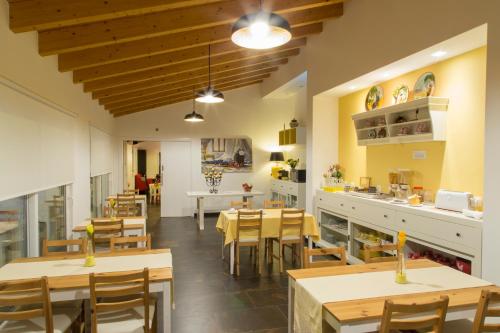 Un restaurante con mesas y sillas de madera y una cocina. en Monte da Ameixa Country House, en Castro Verde