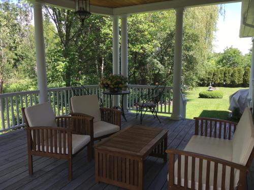 a porch with chairs and a table and a table at Williston Village Inn in Burlington