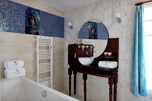 a bathroom with a sink and a mirror at Chambres d'hôtes Les 4 Vents Pointe du Hoc - Landing Beaches in Grandcamp-Maisy