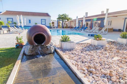 a fountain in the middle of a swimming pool at Monte da Ameixa Country House in Castro Verde