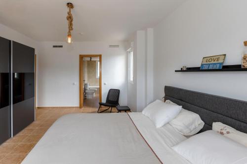 ガータ・デ・ゴルゴスにあるVilla Costa Blancaのベッドルーム(大きな白いベッド1台、椅子付)