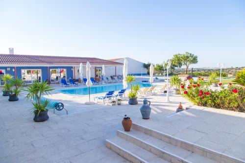 um resort com piscina e algumas plantas em Monte da Ameixa Country House em Castro Verde