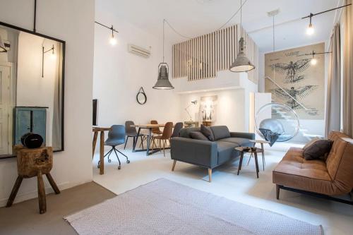 uma sala de estar com um sofá, cadeiras e uma mesa em Danube Riverside DESIGNER apartment in city center em Budapeste