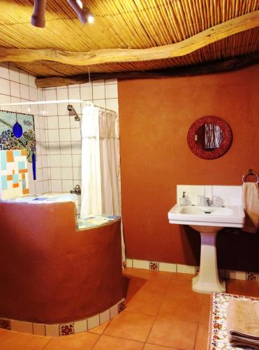 a bathroom with a bath tub and a sink at Rancho Quitapenas Bungalows in San Pedro de Atacama