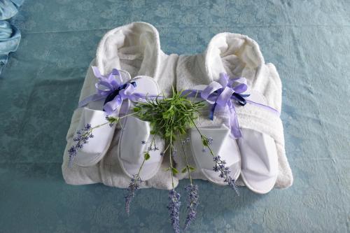 a pair of white shoes with purple flowers in them at B&b Ca'Baracca Bellavista in Bassano del Grappa